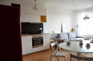een keuken en een woonkamer met een tafel en stoelen bij Brand new apartment. Parking spot included! in Bratislava