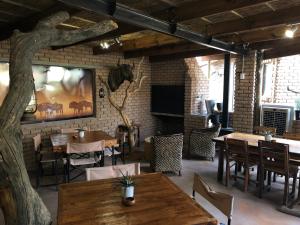 a restaurant with tables and chairs and a brick wall at Country Lodge in Upington