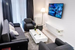 a living room with a couch and chairs and a tv at D&E - PARIS-DISNEY - HOLIDAYS APARTMENT - APPARTEMENT DE VACANCES - 5 CHAMBRES- 5 SDB - 5 BEDROOMS - 5 BATHROOMS - Netflix in Champs-Sur-Marne