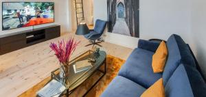 a living room with a blue couch and a glass table at Harbour View in Sønderborg