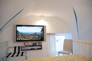 una camera da letto con TV a schermo piatto a parete di La Rosa dei Venti - Levante a Maiori