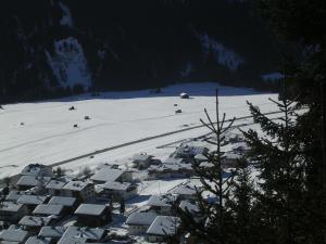 un pueblo en la nieve en una montaña en Gästehaus Obererlacher, en Obertilliach