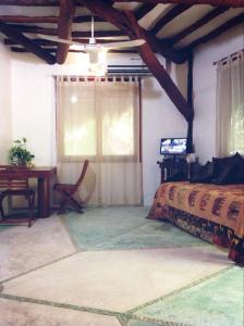 a bedroom with a bed and a desk and a table at La Casa de Juan in Holbox Island