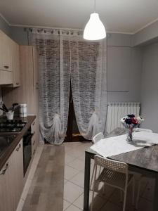 uma cozinha com uma mesa e cadeiras numa cozinha em Anchida casa vacanze em Enna