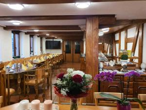 Hotel City Faber في فورمز: مطعم به طاولات وكراسي و إناء من الزهور