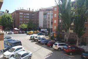 Un estacionamiento con autos estacionados frente a los edificios. en Princesa VUT, en Cuenca