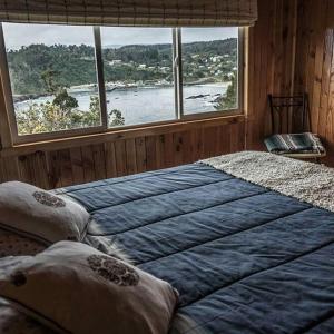 a bedroom with two beds and a large window at Hostería La Casa del Mar in Bahía Mansa