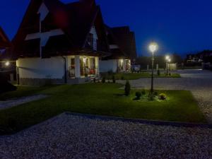 ビャウカにあるApartamenty na Brzyskuの芝生の灯りを持つ家