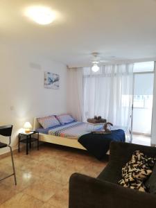 ein Schlafzimmer mit einem Bett und einem Sofa in der Unterkunft ApartBeach Candelaria in Candelaria