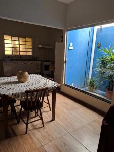 a dining room with a table and a kitchen at Casa para temporada Bonito MS in Bonito