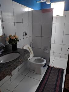 a bathroom with a toilet and a sink at Casa para temporada Bonito MS in Bonito