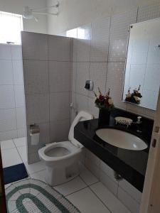 a bathroom with a toilet and a sink and a mirror at Casa para temporada Bonito MS in Bonito