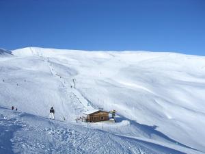 a person is skiing down a snow covered mountain at Gästehaus Obererlacher in Obertilliach