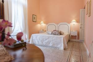 a bedroom with a white bed and two windows at Casa Riccardi in Putignano