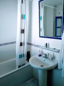 La salle de bains est pourvue d'un lavabo, d'un miroir et d'une baignoire. dans l'établissement WISH SUITE JUDERIA DE SEVILLA, à Séville