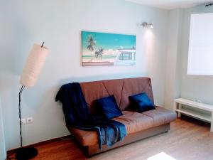 - un canapé avec des oreillers bleus dans le salon dans l'établissement WISH SUITE JUDERIA DE SEVILLA, à Séville