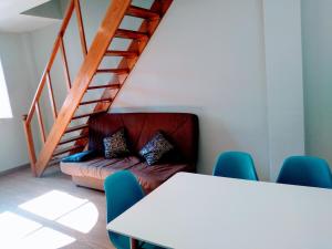Cette chambre dispose d'une table, d'un canapé et d'un escalier. dans l'établissement WISH SUITE JUDERIA DE SEVILLA, à Séville