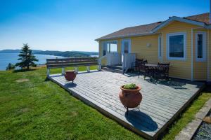 eine Terrasse mit einem Tisch und einer Bank sowie ein Haus in der Unterkunft The Bayside Bed and Breakfast in Bareneed