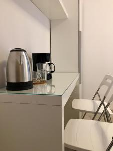 a kitchen counter with a tea kettle and a chair at Orion in Krakow