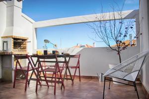 a patio with a table and chairs on a balcony at Vila Mafra - Grill Terrace in Mafra
