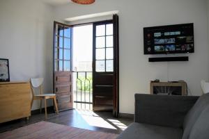 uma sala de estar com um sofá e uma porta de vidro deslizante em Vila Mafra - Grill Terrace em Mafra