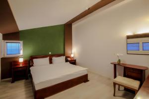 a bedroom with a bed and a green wall at Hotel Aleksandrija in Ohrid