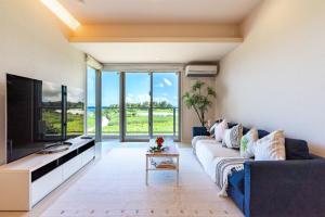 a living room with a couch and a tv at Ocean Resort Maeda / Vacation STAY 3223 in Onna