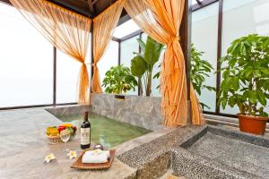 eine Badewanne mit einem Tablett mit Essen und einer Flasche Wein in der Unterkunft The Loft Seaside Suites in Jinshan