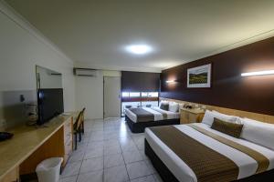 Habitación de hotel con 2 camas y TV de pantalla plana. en Reef Gateway Hotel en Airlie Beach