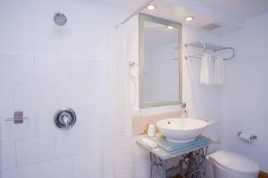 a white bathroom with a sink and a mirror at Blanc Blue 1924 in Havana