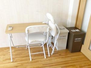 ラ・フィットヤマト103 في فوكوكا: كرسي أبيض جالس في مكتب بجانب صندوق