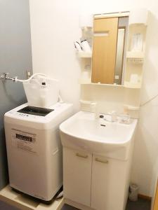 ラ・フィットヤマト103 في فوكوكا: حمام أبيض مع حوض ومرآة