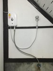 a white wall with a plug and a wire hanging from it at Labelle House in Ko Lanta