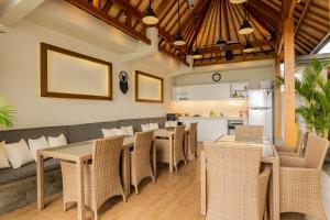 a restaurant with tables and chairs and a kitchen at Bali Harmony Retreat in Canggu