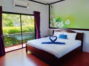 Un dormitorio con una cama con una cinta azul. en บลูออคิดรีสอร์ท ตรัง en Ban Phlu Phli