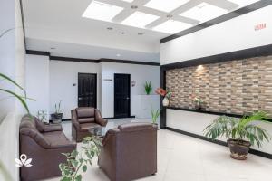 a lobby with two chairs and a brick wall at Check Inn Hotel Dumaguete City by RedDoorz in Dumaguete