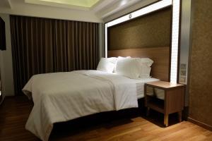 a bedroom with a large bed with white sheets and pillows at Wirton Seminyak in Denpasar