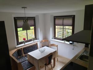 eine kleine Küche mit einem Tisch und 2 Fenstern in der Unterkunft Seiffen Neuhausener Straße 7 Fewo 2 in Kurort Seiffen