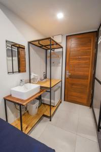 a bathroom with a sink and a wooden door at Sathu Hotel in Chiang Mai