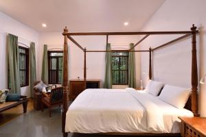 a bedroom with a large bed with a wooden frame at StayVista at Shalom Villa with Pvt Pool & Alfresco Dining in Alleppey +23 photos