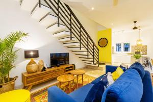 ein Wohnzimmer mit einem blauen Sofa und einer Treppe in der Unterkunft Villa Meya in Seminyak
