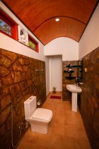 a stone bathroom with a toilet and a sink at Happy Horizon Home Stay in Ella