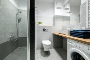 uma casa de banho com um chuveiro, um WC e um lavatório. em Aquarius & FREE PARKING em Sopot