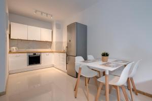 a kitchen with a table and chairs and a refrigerator at Aquarius & FREE PARKING in Sopot