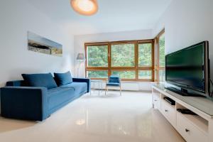 Aquarius & FREE PARKING في سوبوت: غرفة معيشة مع أريكة زرقاء وتلفزيون بشاشة مسطحة