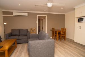 a living room with a couch and a table at Manera Heights Apartments in Dubbo