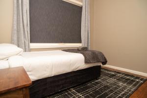 a bedroom with a bed and a window and a table at Manera Heights Apartments in Dubbo