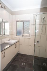 a bathroom with a shower, sink, and tub at Manera Heights Apartments in Dubbo