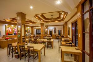 a restaurant with wooden tables and chairs in it at Loei Village Hotel in Loei
