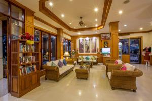 a living room with a couch and chairs and a tv at Loei Village Hotel in Loei